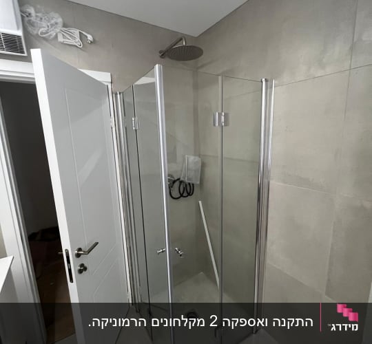 מקלחון זכוכית עם ראש מקלחת עגול על הקיר